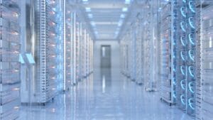 A long data center corridor lined with tall server racks lit blue.